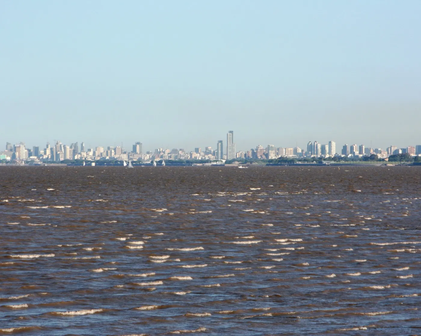 Edificios de Buenos Aires en el horizonte, vistos desde el agua marrón del Río de la Plata